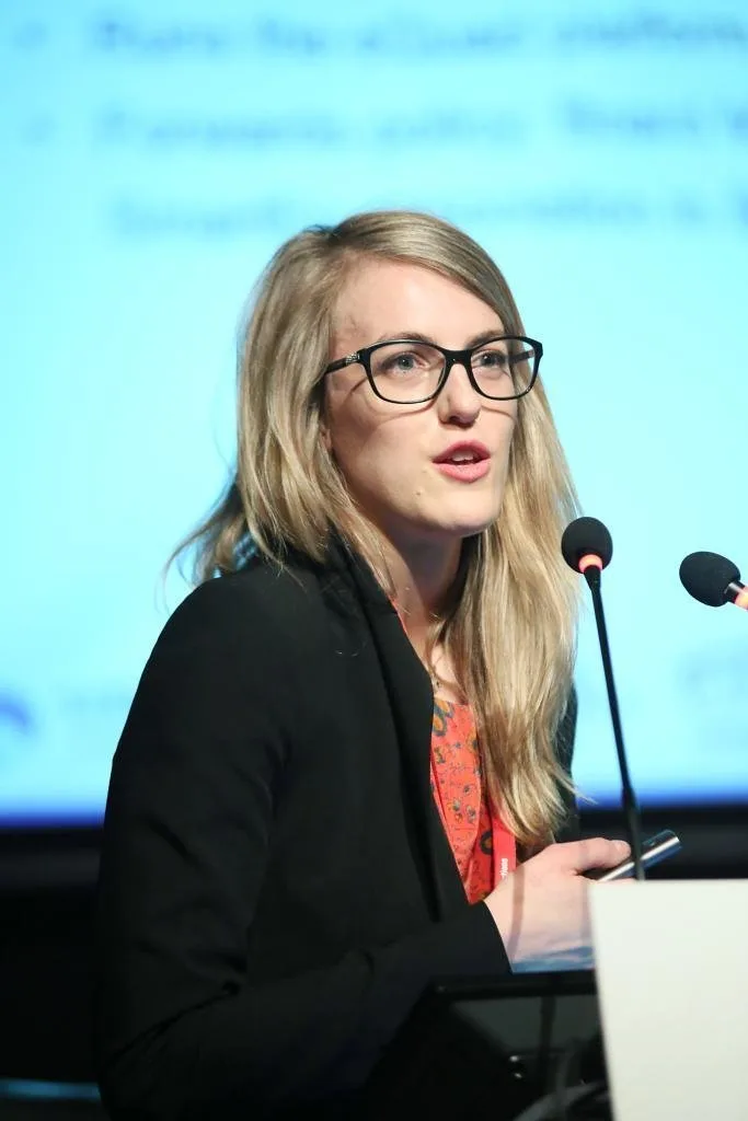 Portrait of Caroline Milne speaking at a podium.